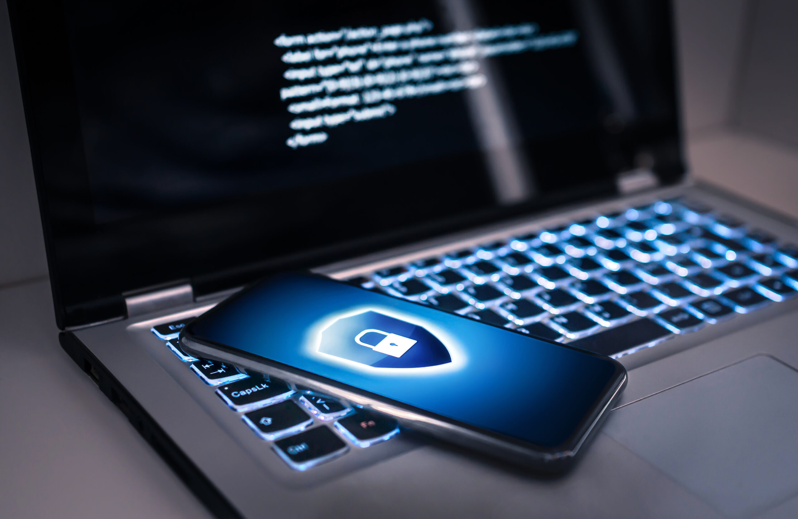 Bloqueo de teléfono para protegerse de estafas cibernéticas, fraude de datos en línea o robo de identidad. Ordenador portátil con código de virus hacker en pantalla. Phishing, peligro de ciberseguridad o ataque de ransomware. dedo presionando la mesa con estrellas y candado de fondo